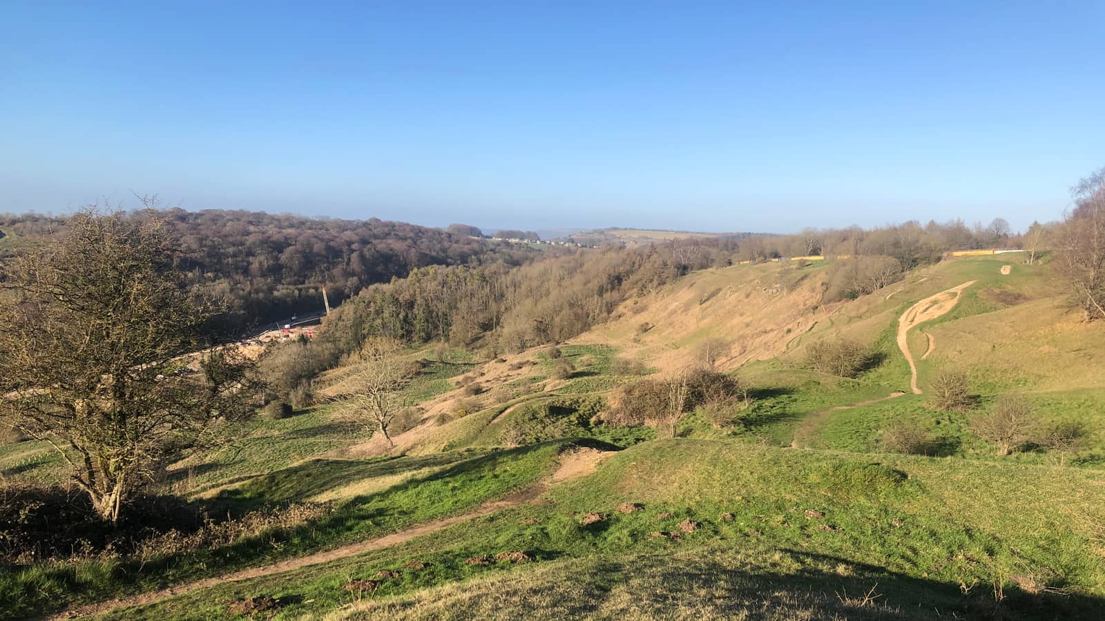 The Cotswold escarpment falling away to the vale, under a clear sky