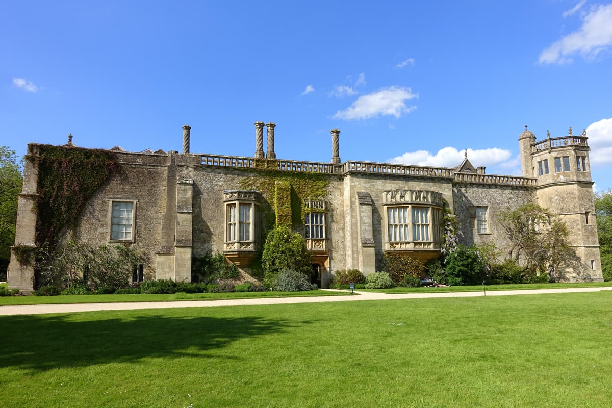 The south front of Lacock Abbey in sunlight, with lawns in front of it